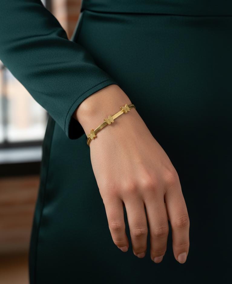 Gold bracelet on a person's wrist with a blurred background