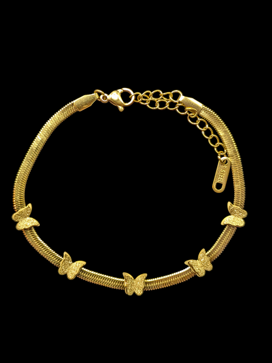 Gold bracelet with butterfly charms on a black background